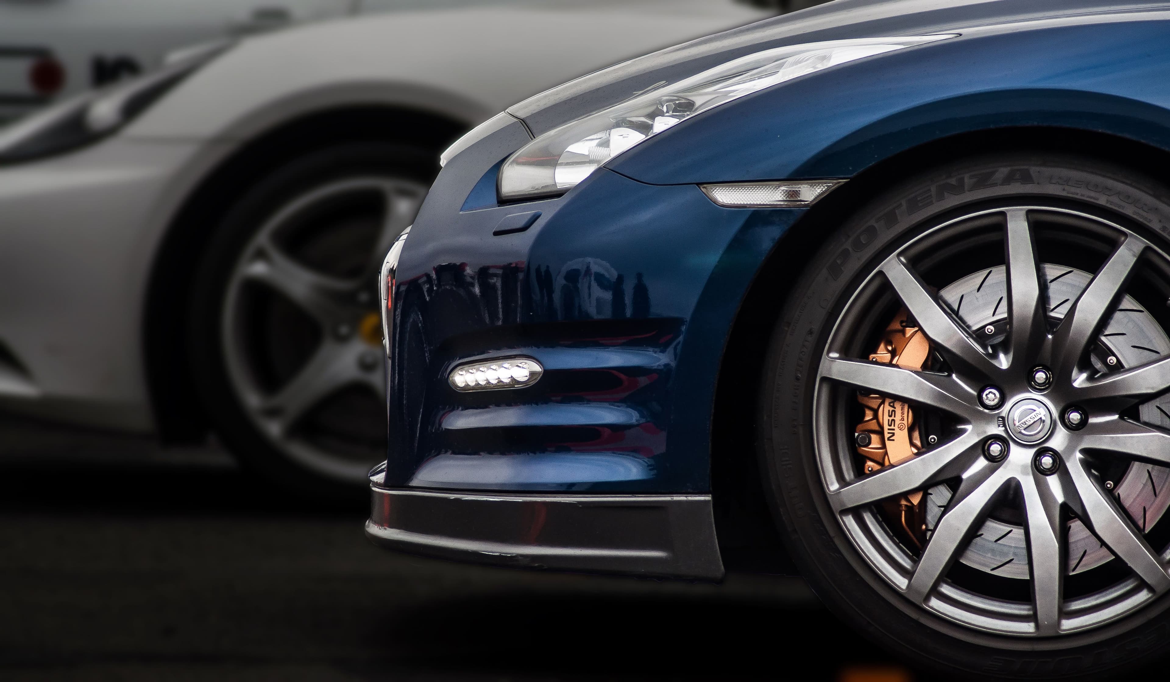 Detailed blue sports car with a polished wheel and finish